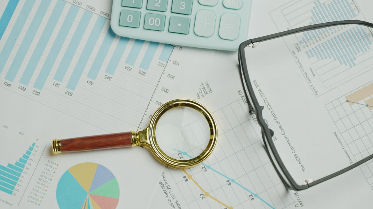 Documents and a magnifying glass on a desk.