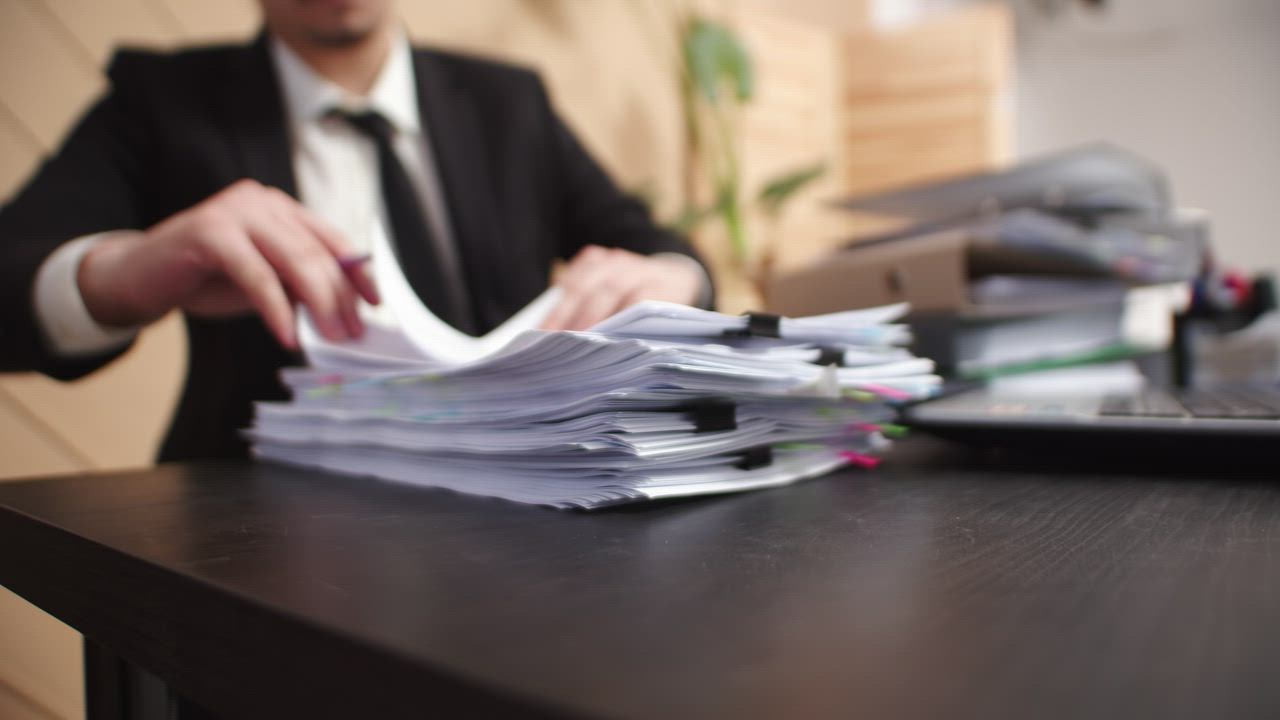 A stack of papers arranged on a desk.